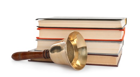 Golden school bell with wooden handle and stack of books on white background