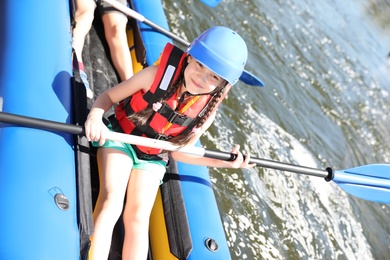 Photo of Little girl kayaking on river. Summer camp