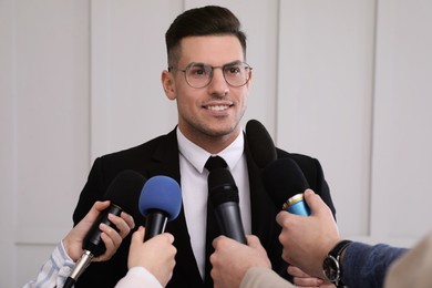 Photo of Happy business man giving interview to journalists at official event