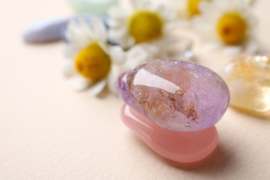 Beautiful gemstones on beige table, closeup. Healing crystals