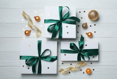 Flat lay composition with beautiful gift boxes and different Christmas decor on white wooden table