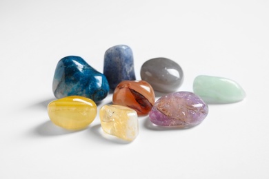 Photo of Pile of different beautiful gemstones on white background