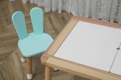 Small table and chair with bunny ears in children's room