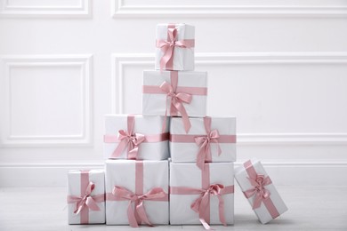 Many gift boxes on floor near white wall in room