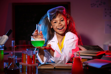 Child doing chemical research in laboratory. Dangerous experiment