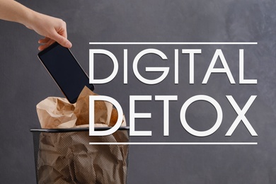 Digital detox concept. Woman throwing smartphone into trash bin near text on grey background, closeup