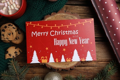 Flat lay composition with greeting card and Christmas decor on wooden background