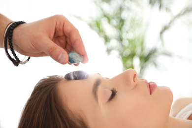 Young woman during crystal healing session in therapy room
