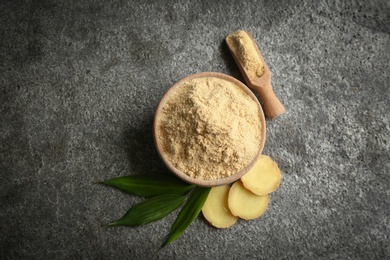 Dry ginger powder, fresh root and leaves on grey table, flat lay