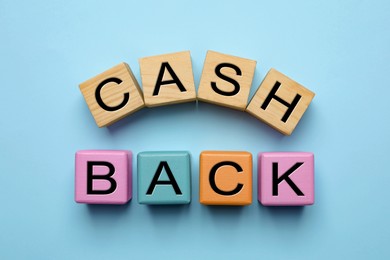 Word Cashback made with cubes on light blue background, flat lay