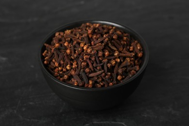 Bowl of aromatic dry cloves on black table