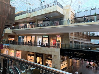 Photo of WARSAW, POLAND - JULY 17, 2022: Big shopping mall with many stores and customers