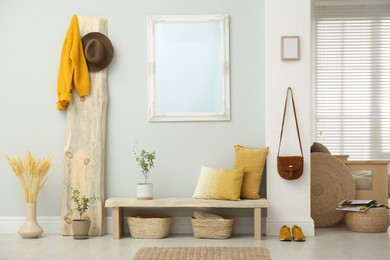 Hallway interior with wooden bench, clothes and mirror