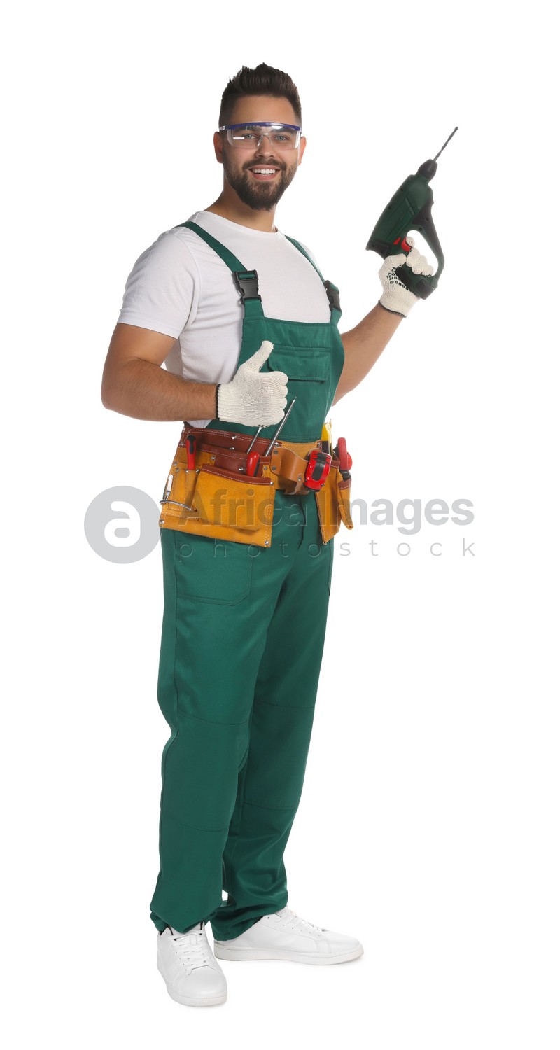 Young worker in uniform with power drill on white background