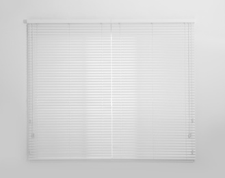 Window with white closed blinds in room