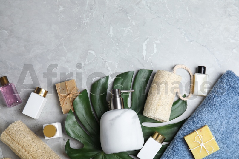 Flat lay composition with soap dispenser on grey marble background. Space for text