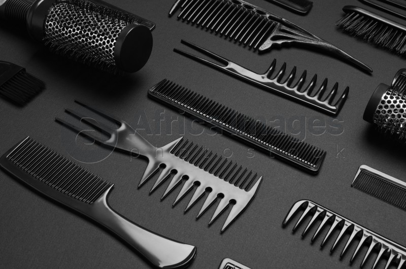 Composition with modern hair combs and brushes on black background