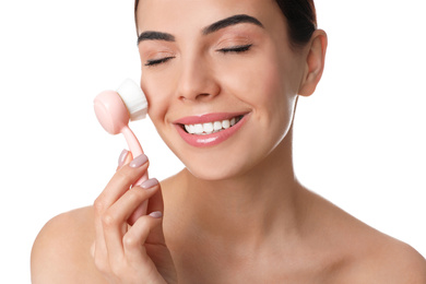 Young woman using facial cleansing brush on white background. Washing accessory