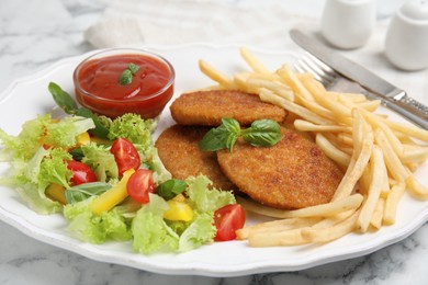 Photo of Delicious fried breaded cutlets with garnish served on white marble table, closeup