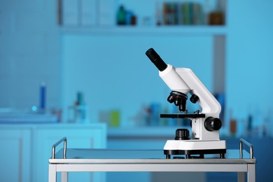 Modern medical microscope on metal table in laboratory, space for text