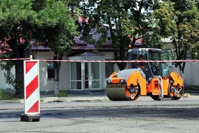 Modern roller working on city street. Road repair