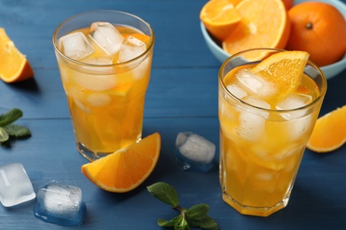 Delicious orange soda water on blue wooden table