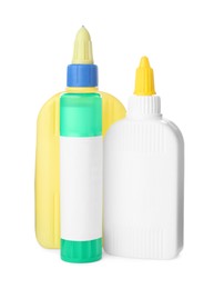 Different bottles and stick of glue on white background