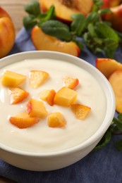 Delicious yogurt with fresh peach on table, closeup