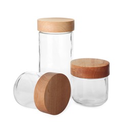 Three empty glass jars with wooden lids isolated on white