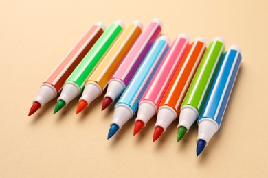 Photo of Many bright colorful markers on beige background