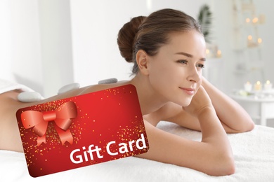 Spa salon gift card. Happy young woman having hot stone massage
