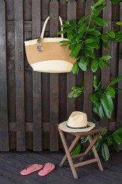 Different stylish beach accessories near wooden fence outdoors