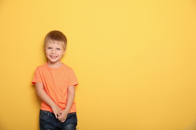 Portrait of cute little boy against color background with space for text