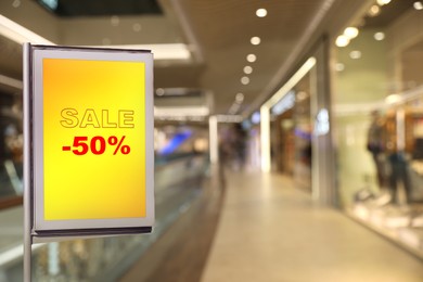 Advertising board with text SALE and 50 percent discount in shopping mall. Special promotion