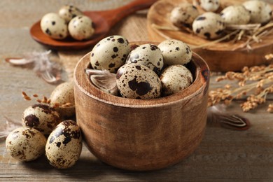 Bowl and quail eggs on wooden table