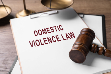 Clipboard with words DOMESTIC VIOLENCE LAW and gavel on wooden table