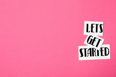 Sheets of paper with phrase Let's Get Started on pink background, flat lay. Space for text