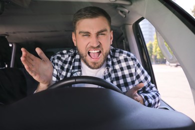 Emotional man in car. Aggressive driving behavior