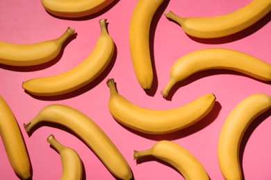 Ripe yellow bananas on pink background, flat lay