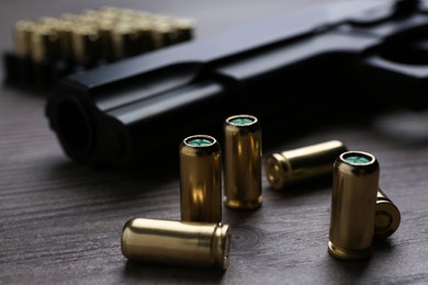 Pistol bullets on wooden table, closeup. Professional gun