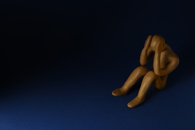 Plasticine figure of crying human on dark blue background. Space for text