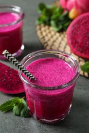 Delicious pitahaya smoothie, fruits and fresh mint on grey table