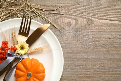 Festive table setting on wooden background, flat lay with space for text. Thanksgiving Day celebration