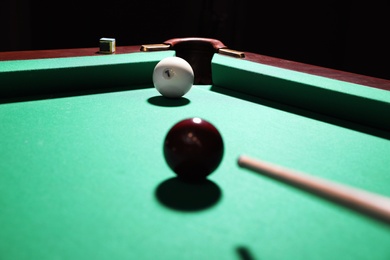 Striking red ball into billiard table pocket