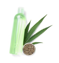 Bottle of hemp cosmetics with green leaf and seeds isolated on white, top view