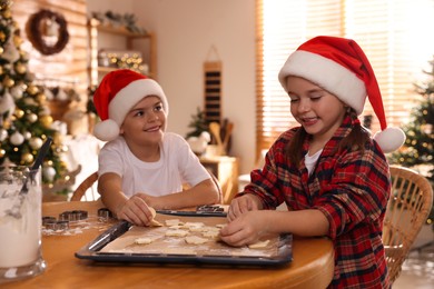 Cute little children making delicious Christmas cookies at home