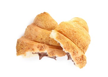Halves of tasty croissant with chocolate and sesame seeds on white background, top view