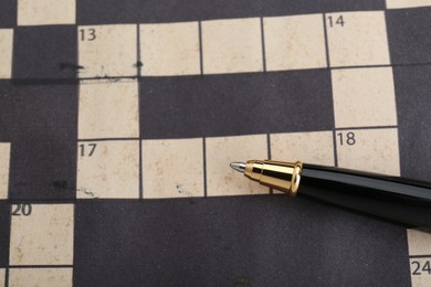 Photo of Pen on blank crossword, top view. Space for text