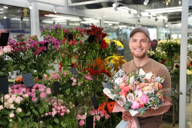 Delivery man with beautiful bouquet in flower shop