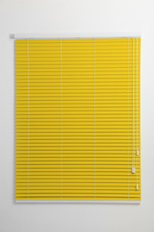 Window with closed yellow blinds in room